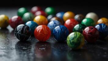 Marbles clustered on black surface, various colored marble tops. photo