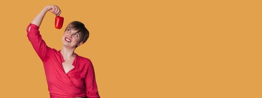 Smiling Caucasian girl with fresh bell peppers in one hand. Panoramic banner, free space. photo