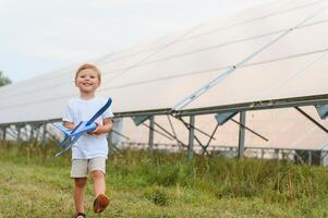 A little boy is having fun near the solar panels. The concept of solar energy. photo