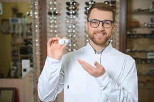 Doctor holds in his hand container with soft contact lenses for single use. Ophthalmologist prescribes use of one-day contact lenses for vision correction. Myopia and eyesight problem concept. photo