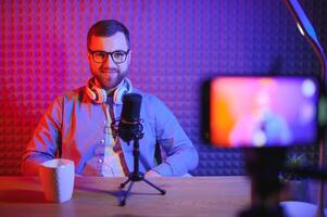 A blogger records content in his studio. The backstage photo was taken from behind one of the participants in the shooting, at the beginning of the shooting when the blogger is preparing.