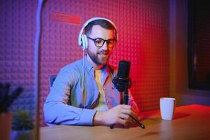 A blogger records content in his studio. The host of the blog is a young man who is very enthusiastic about telling his subscribers a story. photo
