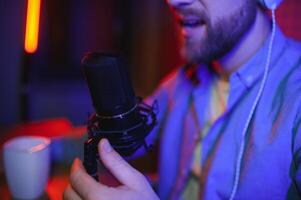 A blogger records content in his studio. The host of the blog is a young man who is very enthusiastic about telling his subscribers a story. photo