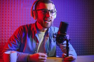 A blogger records content in his studio. The host of the blog is a young man who is very enthusiastic about telling his subscribers a story. photo