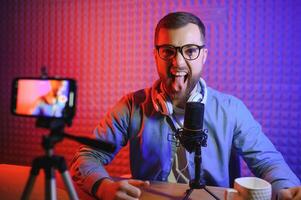 A blogger records content in his studio. The host of the blog is a young man who is very enthusiastic about telling his subscribers a story. photo