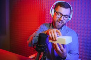 Young man recording or streaming podcast using microphone at his small broadcast studio. Content creator. photo