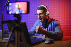 vlogger using smartphone to film podcast in studio. blogger with mobile phone, microphone and headphones filming for social media broadcasting career. photo