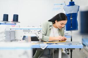 Portrait of a beautiful seamstress carrying a tape measure and working in a textile factory photo