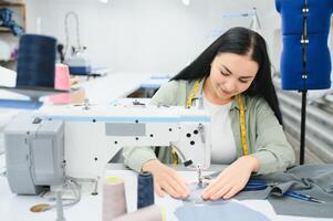 Portrait of a beautiful seamstress carrying a tape measure and working in a textile factory photo
