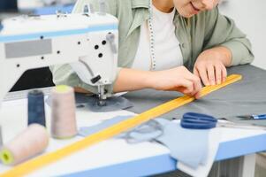 Portrait of a beautiful seamstress carrying a tape measure and working in a textile factory photo
