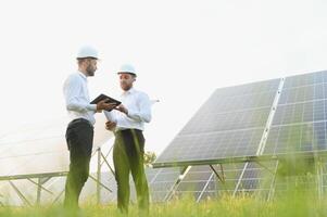engineer and businessman planing new ecology project. around solar panel roof photo