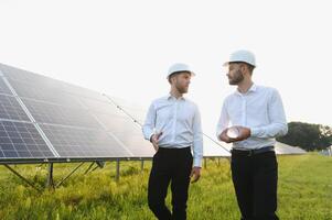 engineer and businessman planing new ecology project. around solar panel. photo