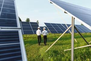 engineer and businessman planing new ecology project. around solar panel roof photo