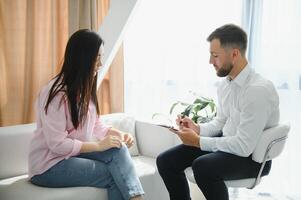 Male doctor and female patient at therapy session photo