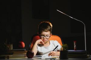 boy doing homework at home in evening photo