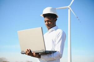 Engineer African man standing with wind turbine photo