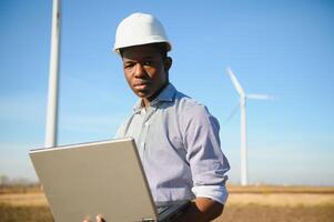 Engineer African man standing with wind turbine photo