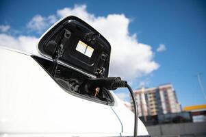 poder suministro para eléctrico coche cargando eléctrico coche cargando estación. cerca arriba de el poder suministro atascado dentro un eléctrico coche siendo cargado. foto