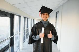 retrato de exitoso indio estudiante en graduación vestido. foto