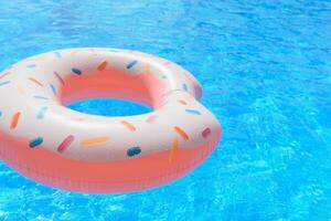 Inflatable swim ring in shape of donut floating in pool photo