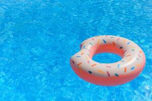 Inflatable swim ring in shape of donut floating in pool photo
