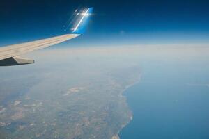 Clouds and sky as seen through window of an aircraft photo