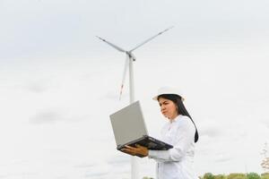 Environmental engineer with a laptop at wind farm photo