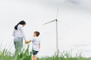 Alternative energy, wind farm and happy time with your family. Happy mother on the road with his son on vacation and escape to nature. photo