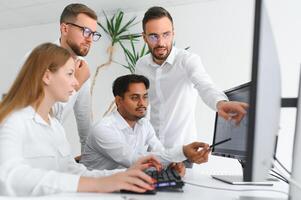 Happy businesspeople laughing while collaborating on a new project in an office. Group of diverse businesspeople working together in a modern workspace photo