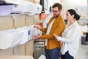 A beautiful couple chooses an air conditioner at home in an electronics store photo