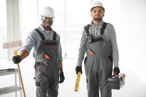 multicultural builders in hardhats at construction site photo