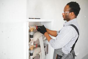 The worker installs or inspects Fire extinguisher and fire hose reel in building corridor photo