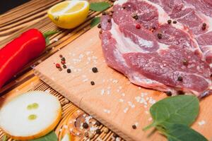 Raw pork chop steak prepare in kitchen with vegetable and spices for food and cooking concept photo