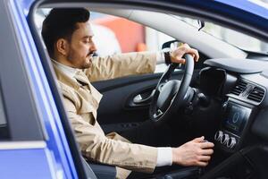 Close-up of man looking at his watch on his hand while sitting in his car he hurrying to a meeting photo
