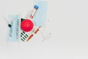 Surgical mask protective mask with CORONAVIRUS text. Virus 2019-n CoV in Wuhan, China. Tablets, mask, syringe photo