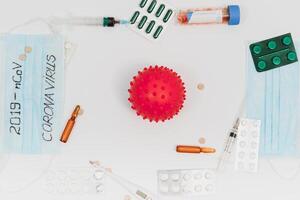 a test tube with a positive test for the CAVID-2019 coronavirus. medical devices on a white table. thermometer, phonendoscope, tablets, surgical masks photo