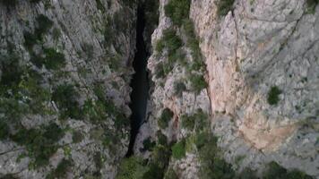 Drone footage over mountain river in gorge, showcasing rocky landscape. Aerial view highlights the turquoise water flowing through gorge. Explore the natural beauty of the gorge in vivid detail video