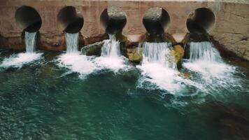 Drone view of spillway in fast mountain stream. Crystal clear water flows through spillway. Aerial footage captures dynamic spillway in rocky terrain video
