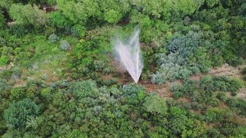 Drone view captures pipe, spraying water in green mountain canyon. Aerial footage shows pipe, spraying fountain due to break. Environmental impact visualized by pipe, spraying in nature. video