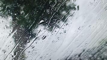 View from inside the windscreen of a car in heavy rain with many drops on the windscreen. video