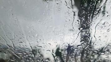 View from inside the windscreen of a car in heavy rain with many drops on the windscreen video