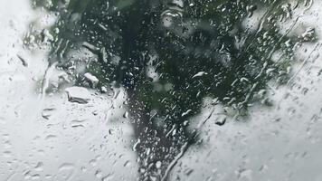 View from inside the windscreen of a car in heavy rain with many drops on the windscreen. video