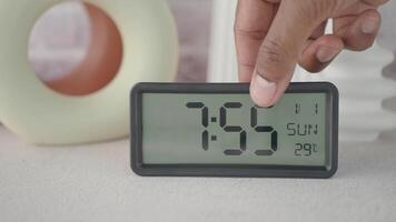 Start your day right by placing a digital alarm clock on a table to wake up in the morning video