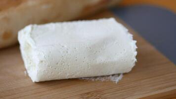 A delectable presentation of creamy goat cheese arranged on a rustic wooden cutting board video