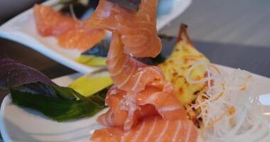 Picking pieces of red salmon fish on a plate in a buffet. cook cuts pieces of lightly salmon. Trout. Red fish. video