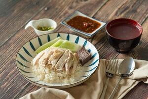 Hainanese Chicken rice with salted soya beans sauce and soup on wooden table photo