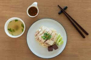 Top view Singapore chicken rice with salted soya beans sauce and soup on wooden background photo