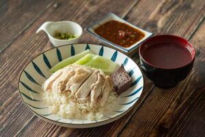 Traditional Hainanese Chicken rice with salted soya beans sauce and soup photo