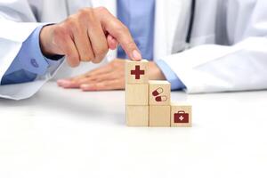 Hand holding a wooden block cube with healthcare medical icon symbol. Medical and health concept. photo