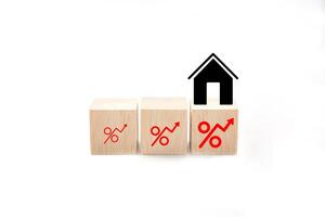 House shape made by wooden block, On the side there are icon rising percentage. Interest rate finance, real estate and house loan concept. photo